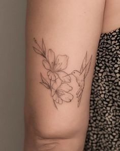 a woman's arm with a flower tattoo on the left side of her arm