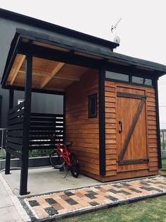 a small wooden shed with a bicycle parked in it