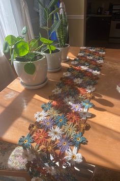 the table is covered with crocheted doily and has potted plants on it