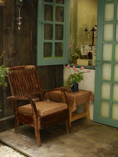 a wooden chair sitting in front of a green door