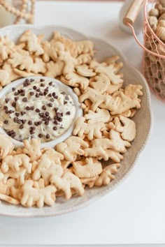 a plate full of cookies and crackers with dip in the middle on a table