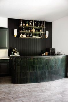 a black and white kitchen with marble counter tops on the wall next to an island