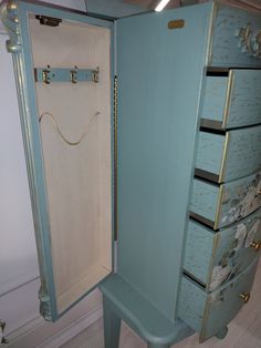 an antique blue jewelry cabinet with drawers