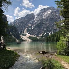 there are many boats on the water in this mountain lake