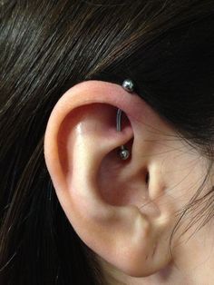 a close up of a person's ear with two piercings