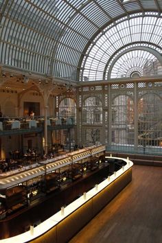 the inside of a building with many tables and chairs in it's center area