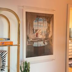 a room with a mirror, shelves and a painting hanging on the wall above it