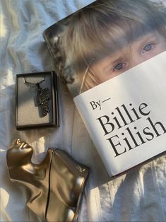 an open book and some other items on a white sheet with a woman's face next to it