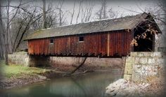 an old wooden covered bridge over a stream