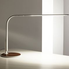 a desk lamp sitting on top of a table next to a white wall and floor