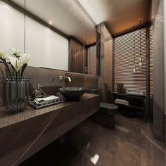 a modern bathroom with marble counter tops and brown tile flooring, along with two vases filled with white flowers