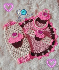 two crocheted baby booties and bib are laying on a white blanket