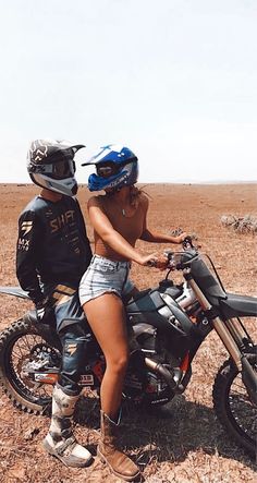 a man and woman riding on the back of a motorcycle in the middle of nowhere