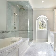 a large bathroom with marble flooring and white walls, along with a walk in shower