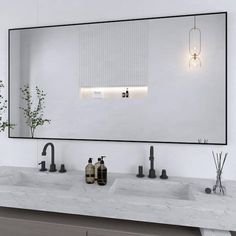 a bathroom with two sinks and a large mirror over it's counter top area