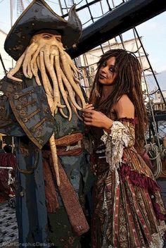 a man and woman dressed up as pirates with dreadlocks standing next to each other