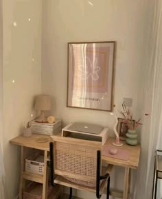 a wooden desk with a laptop on top of it next to a lamp and pictures