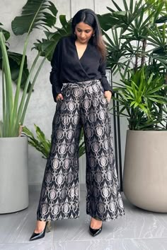 Black wrap shirt featuring a V neckline and full sleeves. Paired with floral jaal brocade woven pant with side pockets., Fit: Relaxed Plazo Shirt Design, Blouse With Pants Outfit, Plazo Shirt Outfit, Elegant Designer Wide Leg Palazzo Set, Elegant Designer Bottoms For Diwali, Festive V-neck Elegant Palazzo Set, Elegant Designer Wear Sets With Wide Legs, Elegant Designer Sets With Wide Legs, Elegant V-neck Sets With Zari Work