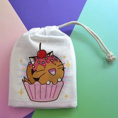 a drawstring bag with a cat on it and a cupcake printed on the front