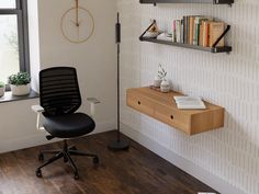 an office chair sitting in front of a desk with a clock on the wall behind it