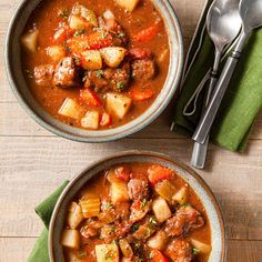 two bowls filled with stew on top of a wooden table