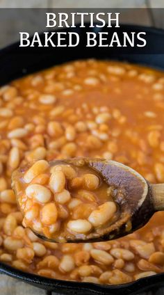 a wooden spoon filled with baked beans on top of a black pan and text overlay reads british baked beans