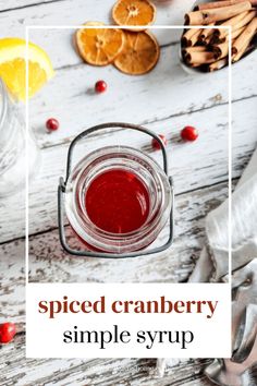 a jar filled with cranberry sauce sitting on top of a white wooden table