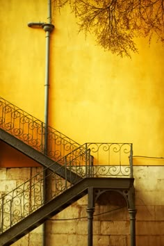 a fire hydrant sitting on the side of a building next to a stair case