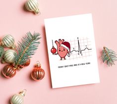 a card with an image of a heart beat on it next to christmas ornaments and decorations