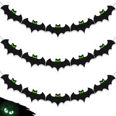 three bats with green eyes hanging from the ceiling in front of a black cat and white background