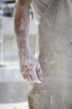 a close up of a person holding something in their hand with dirt on his hands