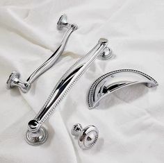 two chrome shower faucets sitting on top of a white sheet