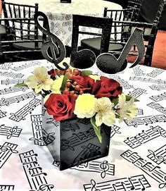 there is a vase with flowers and music notes in it on the dining room table