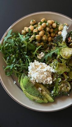 a white plate topped with greens and chickpeas