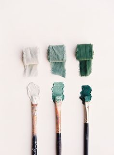 five brushes with different shades of green and white