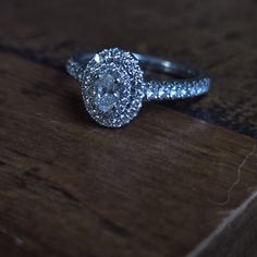 a diamond ring sitting on top of a wooden table