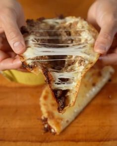 a person holding a slice of pizza with melted cheese