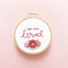 a hand embroidered hoop with the words you are loved on it