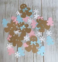 gingerbread cut outs are arranged on a wooden surface with snowflakes and stars