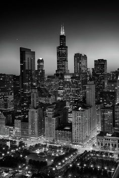 a black and white photo of the city at night with skyscrapers in the background