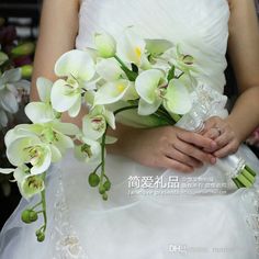 a bride holding a bouquet of white orchids