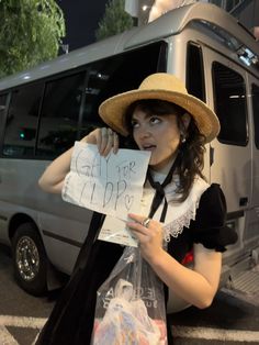 a woman in a hat holding up a sign