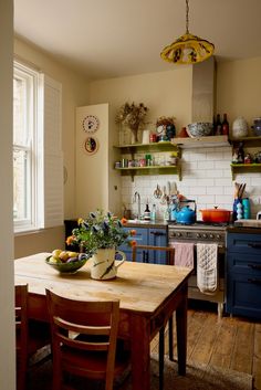 a kitchen with blue cabinets and wooden table