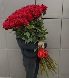 a man holding a bunch of red roses