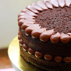 a chocolate cake sitting on top of a wooden table next to an instagram page