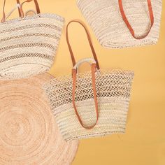 three straw bags with leather handles are shown on a yellow background, one is brown and the other is white