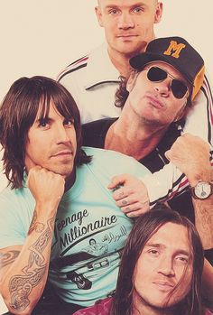 three men with long hair and sunglasses are posing for the camera, while one man has his arm around another man's shoulder