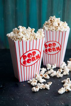 three buckets of popcorn sitting on top of a table