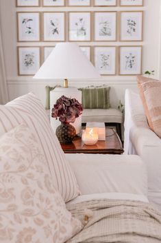 a living room filled with furniture and a table topped with a lit candle on top of a coffee table