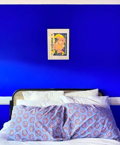 a bed with blue walls and white sheets